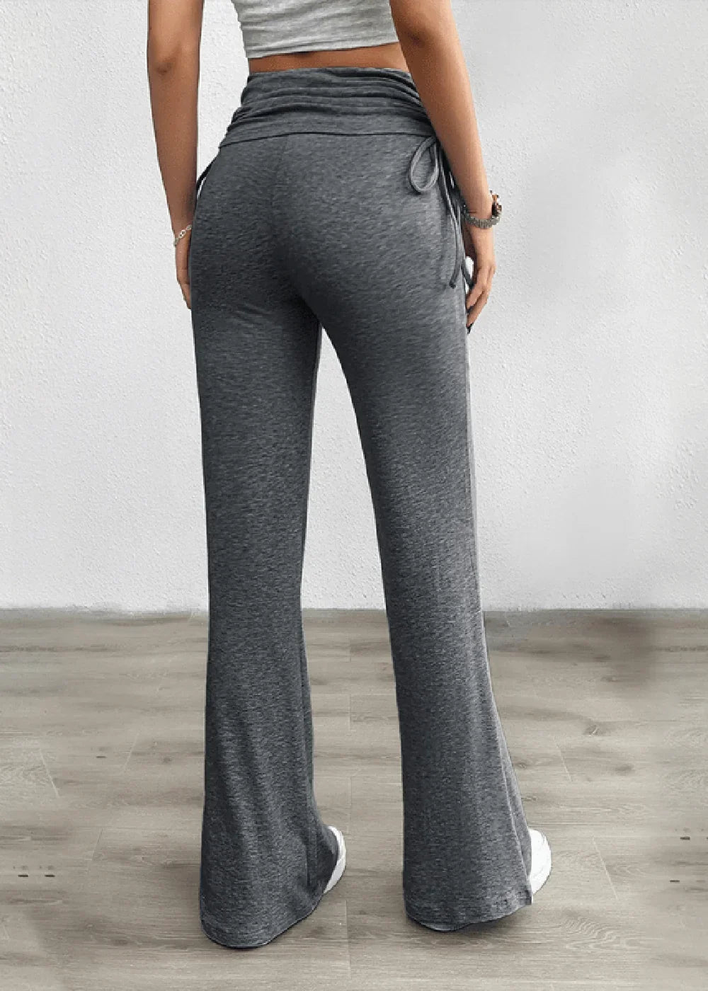 Back view of grey, flared sweatpants with drawstring waist and elastic waistband.