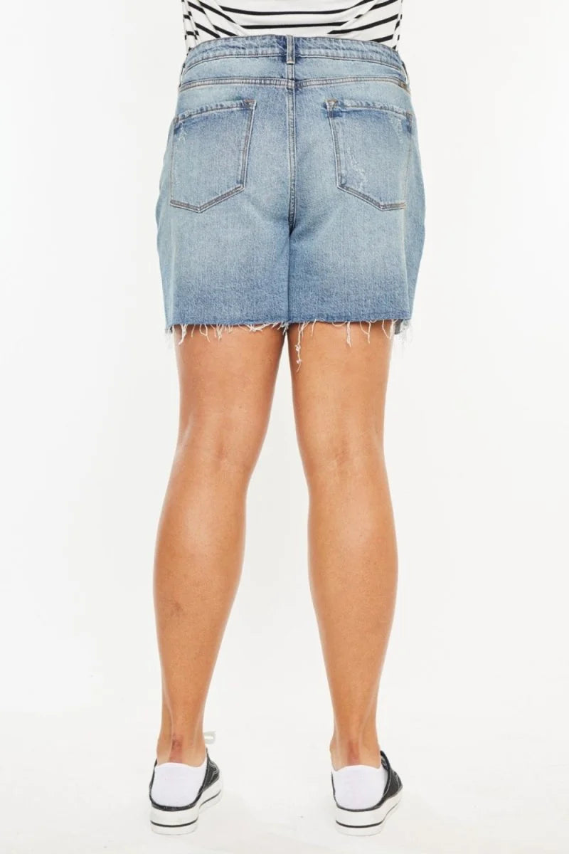 Back view of light wash distressed denim shorts with frayed hem