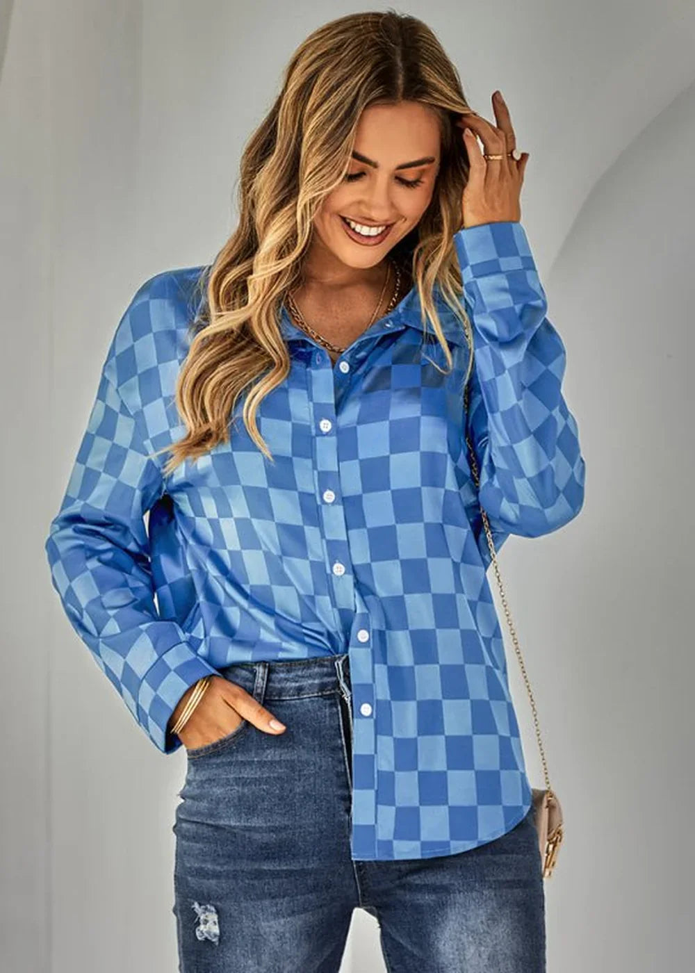 Blue checkered button-down shirt with long sleeves on a model wearing jeans.