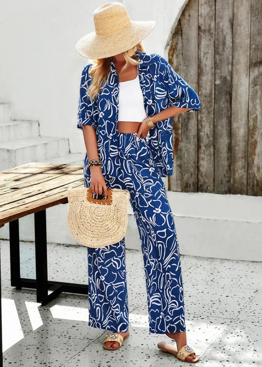 Navy blue and white abstract floral print pantsuit with wide-leg pants on model.