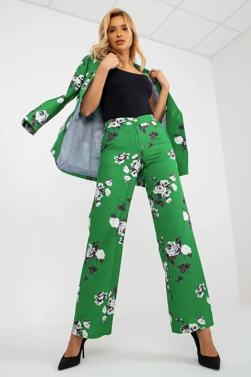 Green wide-leg pants with a bold white and black floral pattern, worn by a model.