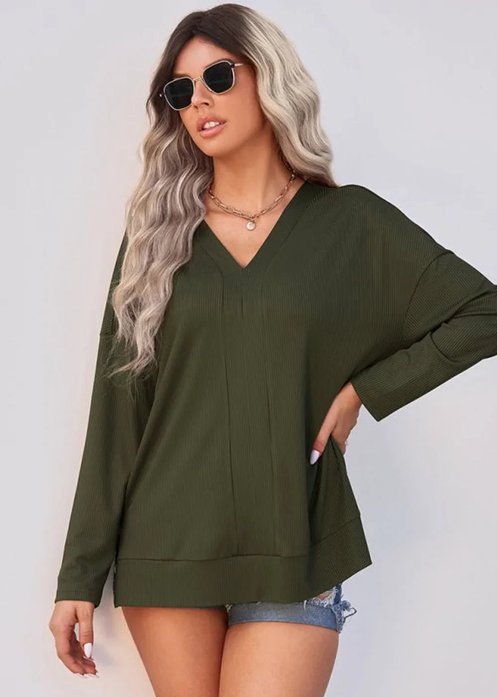 Olive green ribbed V-neck long-sleeve top with a relaxed fit, worn by a model.