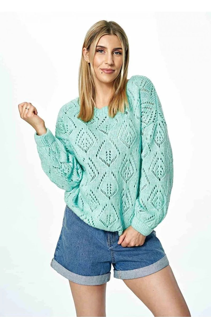 Mint green crochet knit sweater with diamond pattern and cuffed denim shorts on a model.