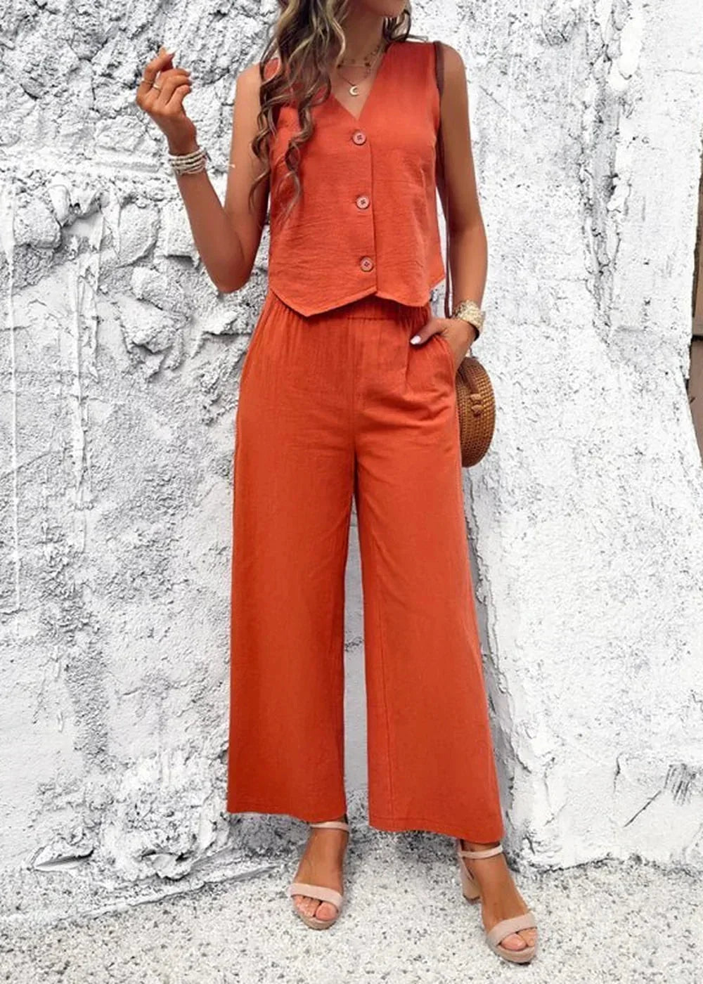 Orange cotton cropped vest and wide-leg pants, v-neck, button front, on model.