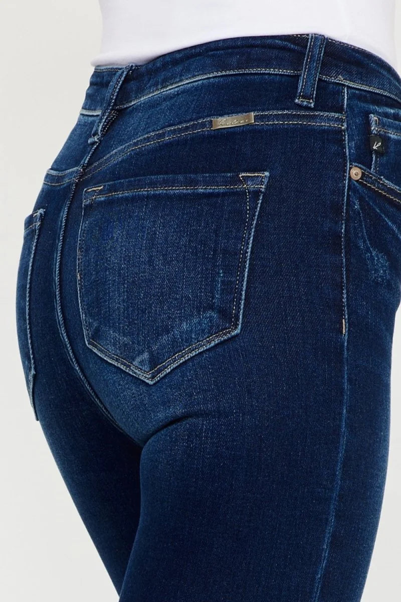 Close-up of dark wash, slightly stretchy denim jeans showing back pockets and waistband detail.