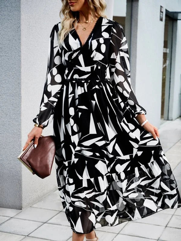 Black and white abstract print midi dress with V-neck and tiered skirt on model.