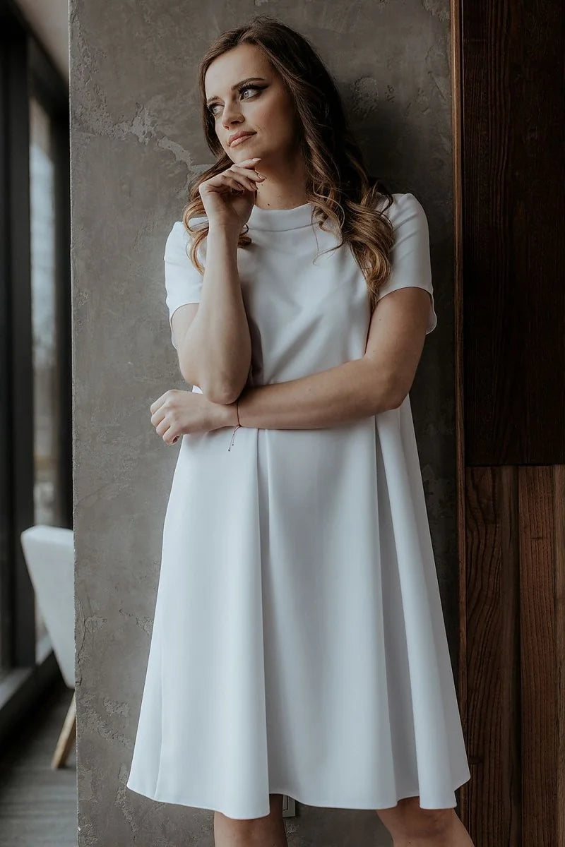 Loose fit white short-sleeve A-line dress with a high neckline on a woman.