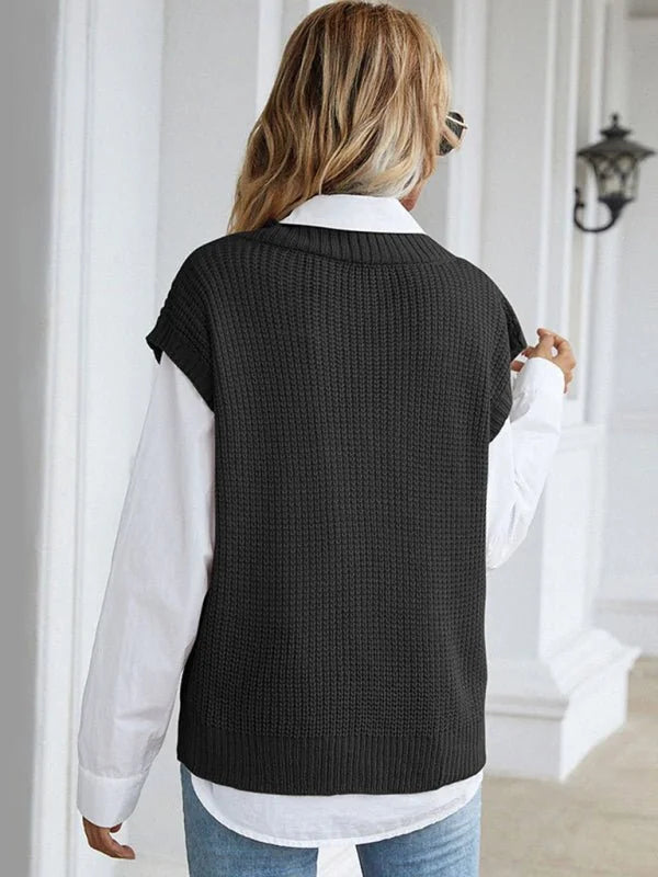 Woman wearing a black textured knit vest over a white collared shirt, back view.