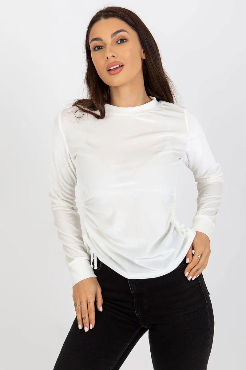 White long-sleeve top with ruched side detail and a crew neck, worn by a model.