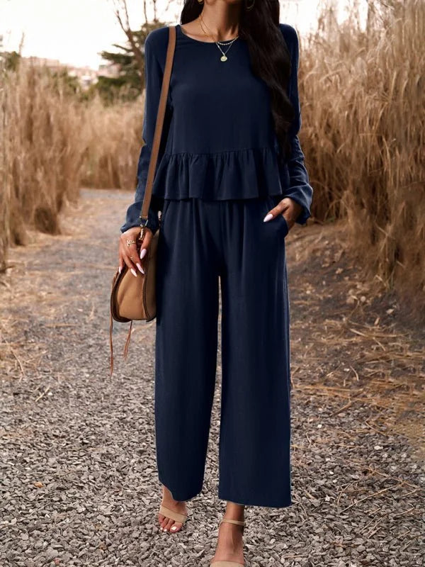 Navy blue relaxed fit pantsuit with ruffled top, on model outdoors.