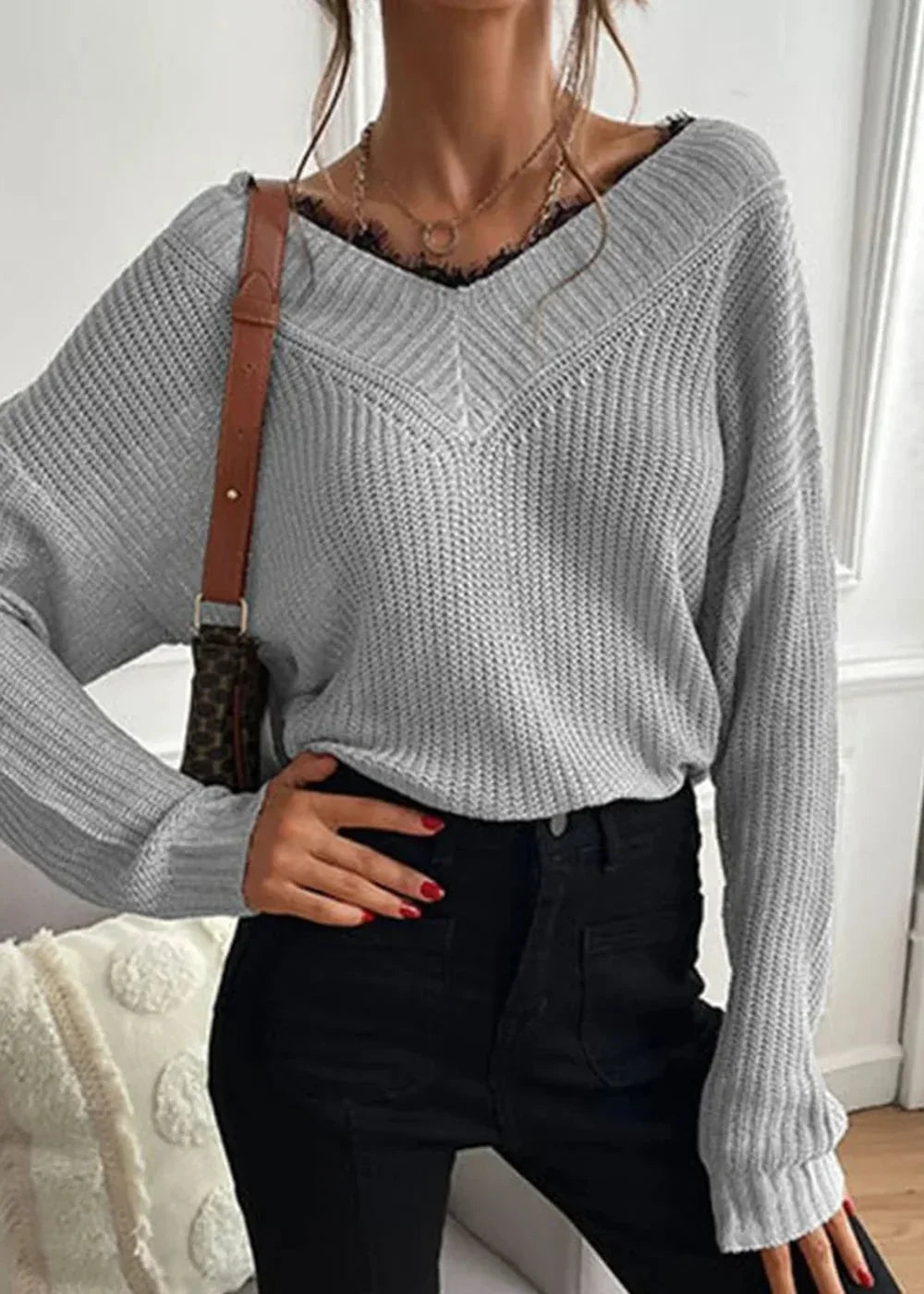 Gray knit v-neck sweater with lace trim and a brown strap bag on model