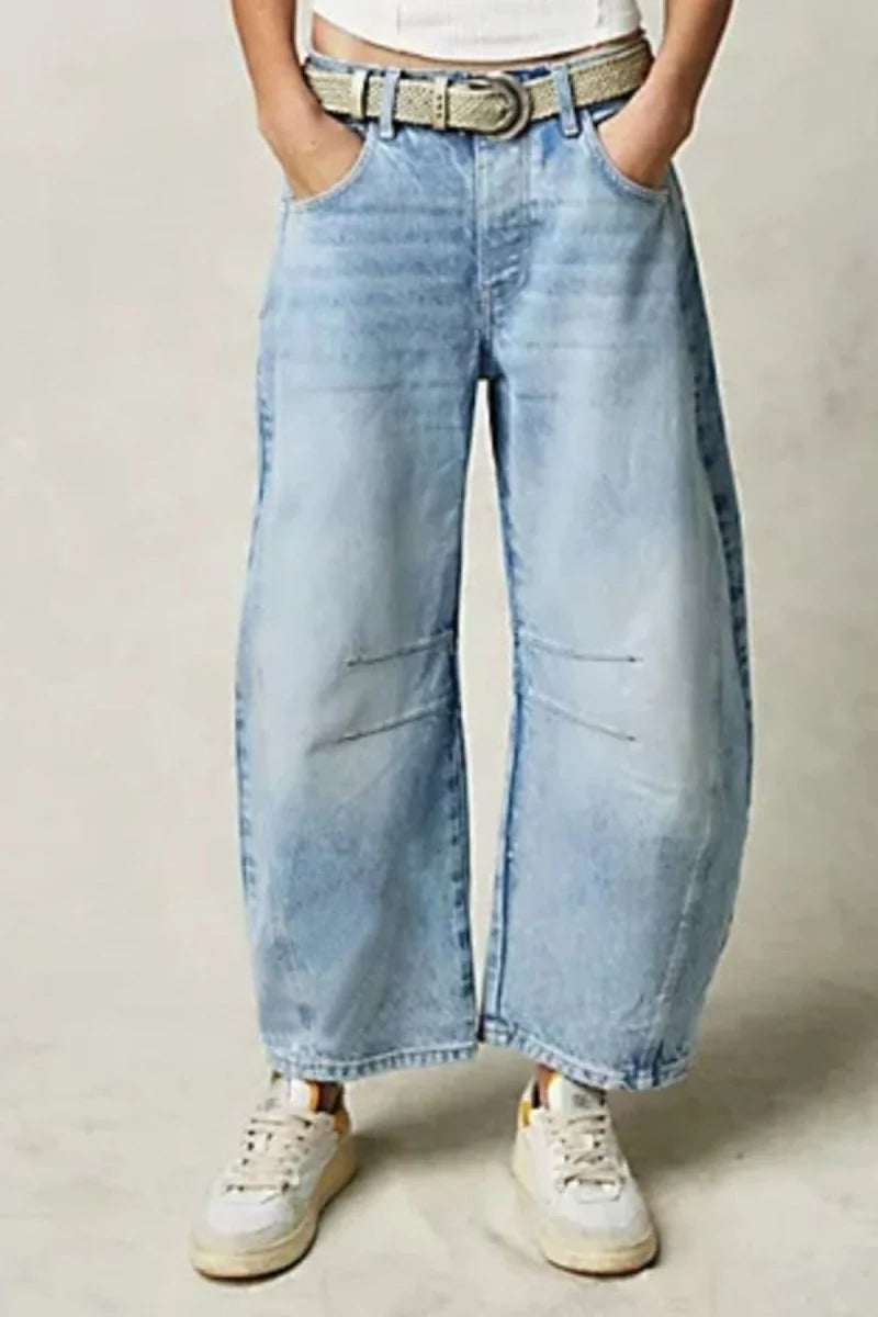 Relaxed fit light wash denim jeans with a wide leg and textured belt.