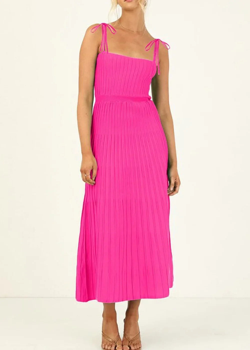 Hot pink pleated knit midi dress with tie straps and square neckline on model.