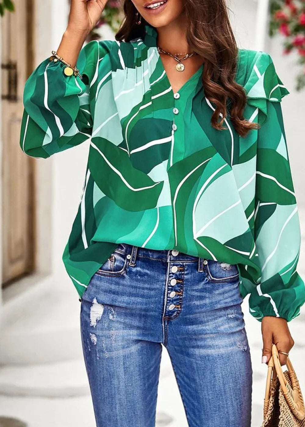 Green and teal abstract leaf print blouse with ruffled collar and button front, paired with distressed denim jeans.