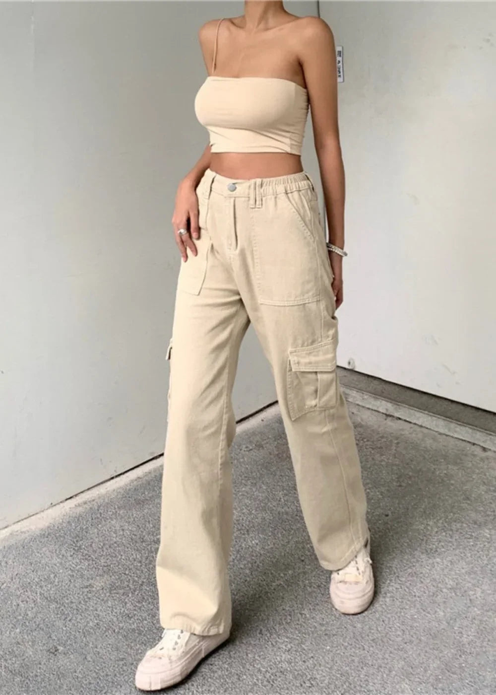 Cream cargo pants with a wide leg fit and large side pockets, worn by a model.