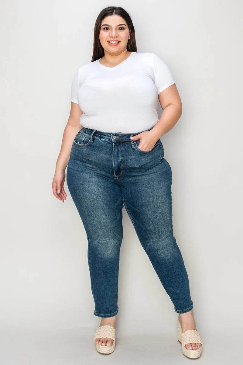 Full-length shot of a plus-size model wearing a white v-neck t-shirt and medium-wash distressed denim jeans with a regular...