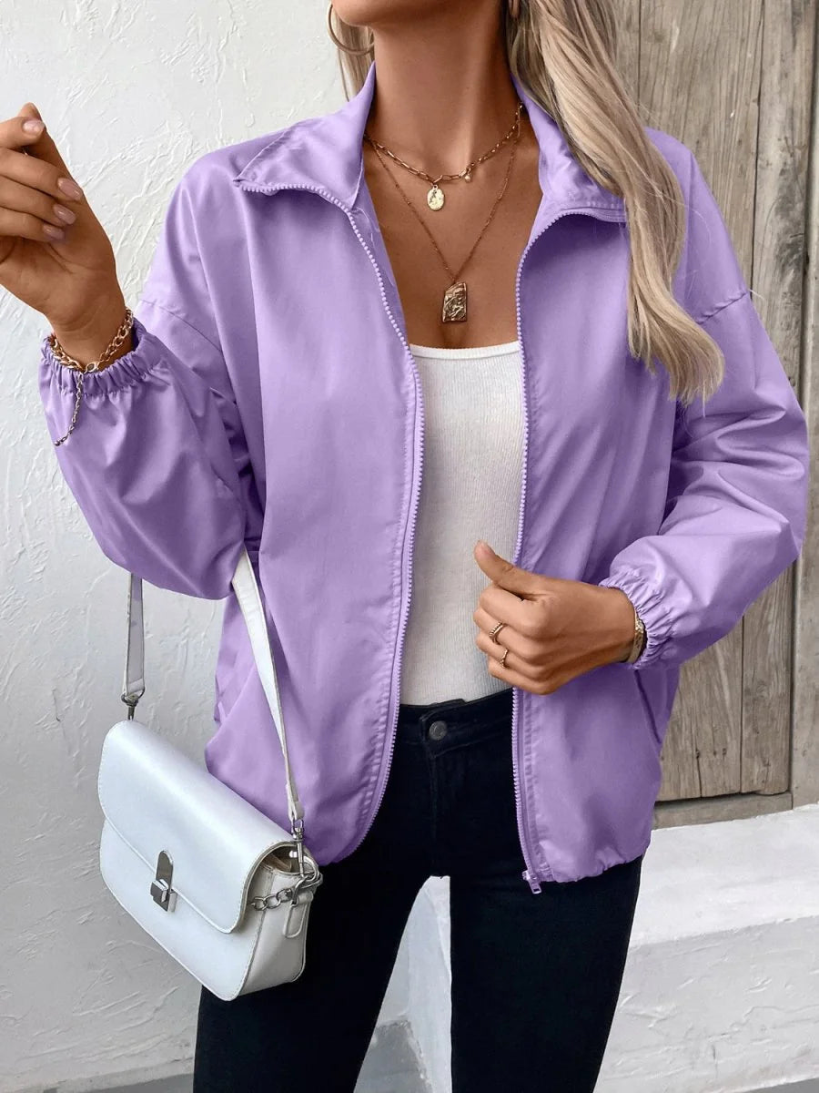 Lavender bomber jacket with a zippered front and elastic cuffs, worn by a model.