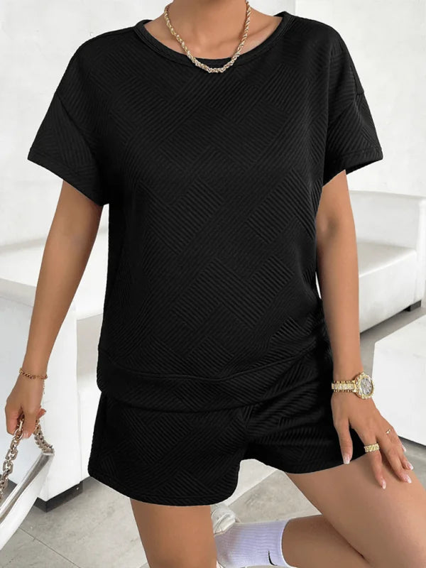 Black textured short suit with a crew neck top and shorts on a model.