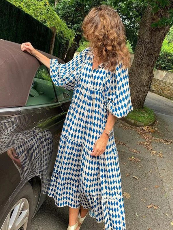 Blue and white geometric diamond pattern tiered midi dress with a v-neck and flutter sleeves.