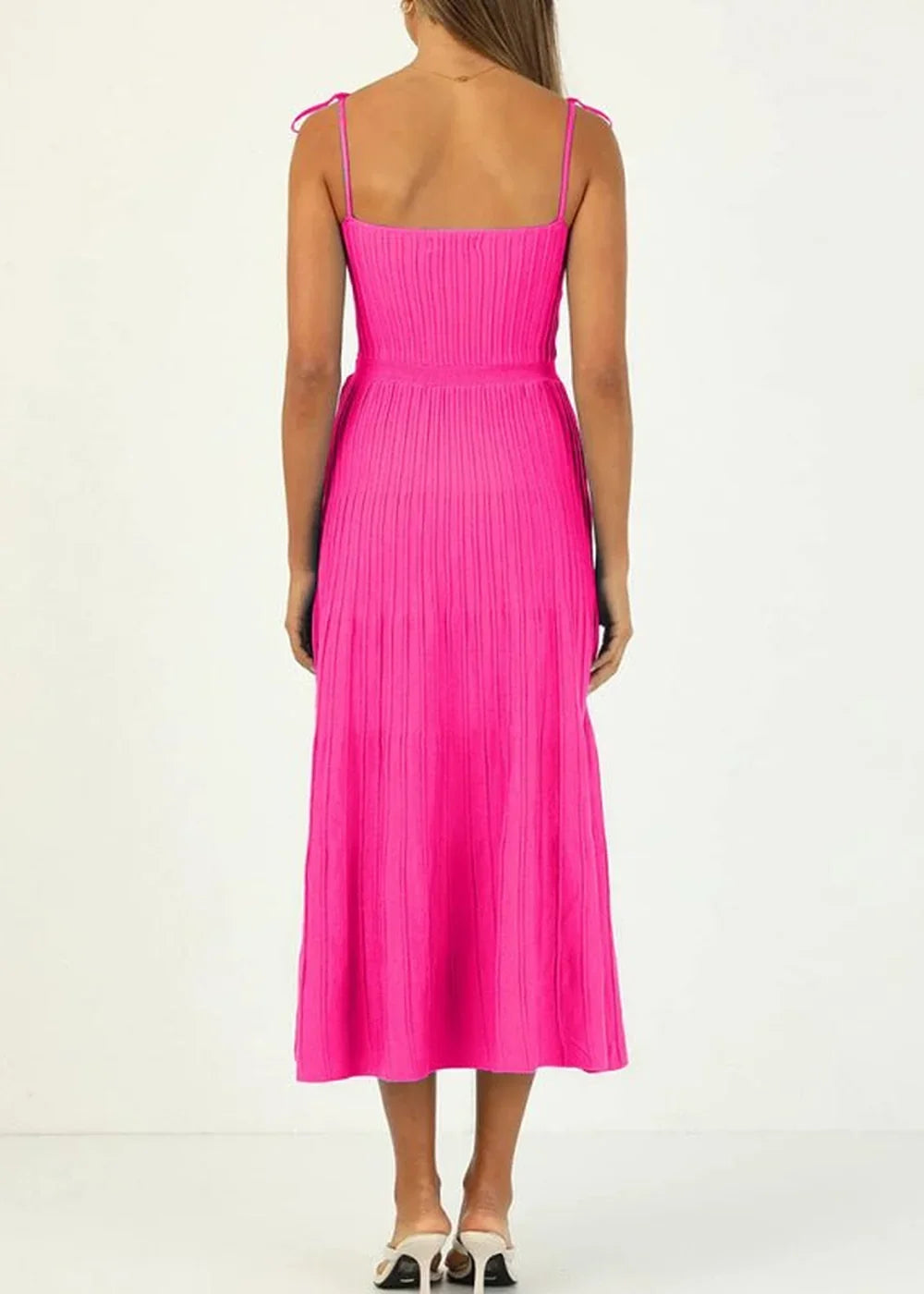 Hot pink knit midi dress with spaghetti straps, ribbed texture, and a tie waist, shown from the back.