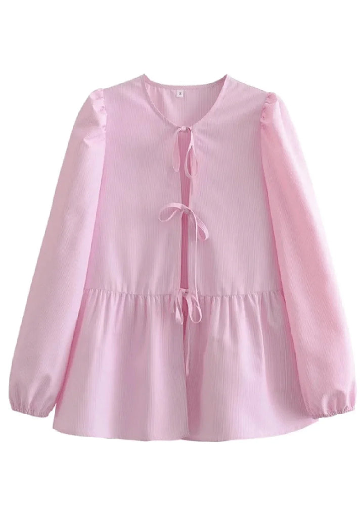 Light pink peplum top with tie closures and puff sleeves.