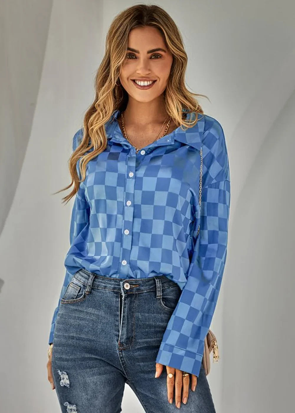 Blue and light blue checkered long-sleeve button-up shirt with a gold chain necklace on a smiling woman.