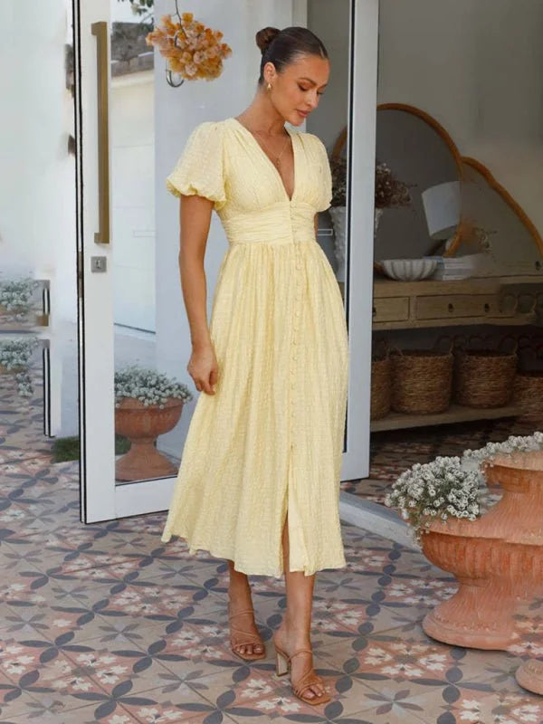 Yellow textured midi dress with puff sleeves and button front, on model.