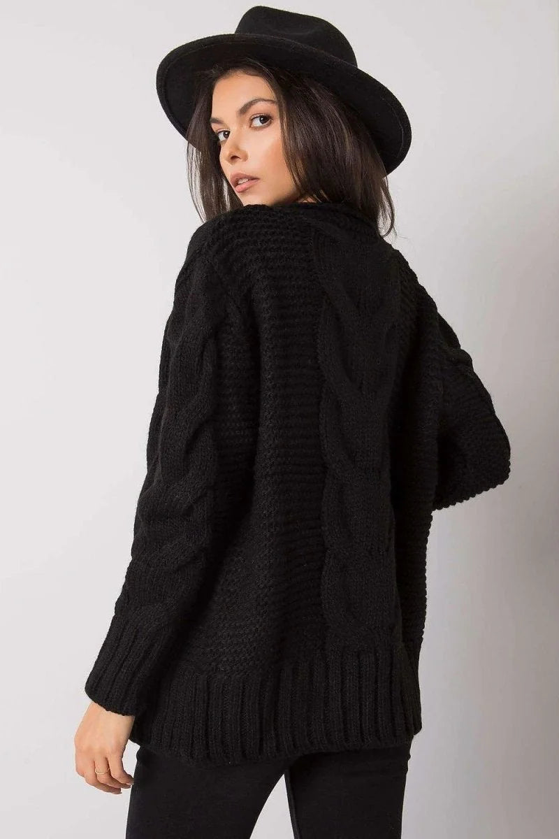 Woman in a black cable knit sweater and fedora hat, back view