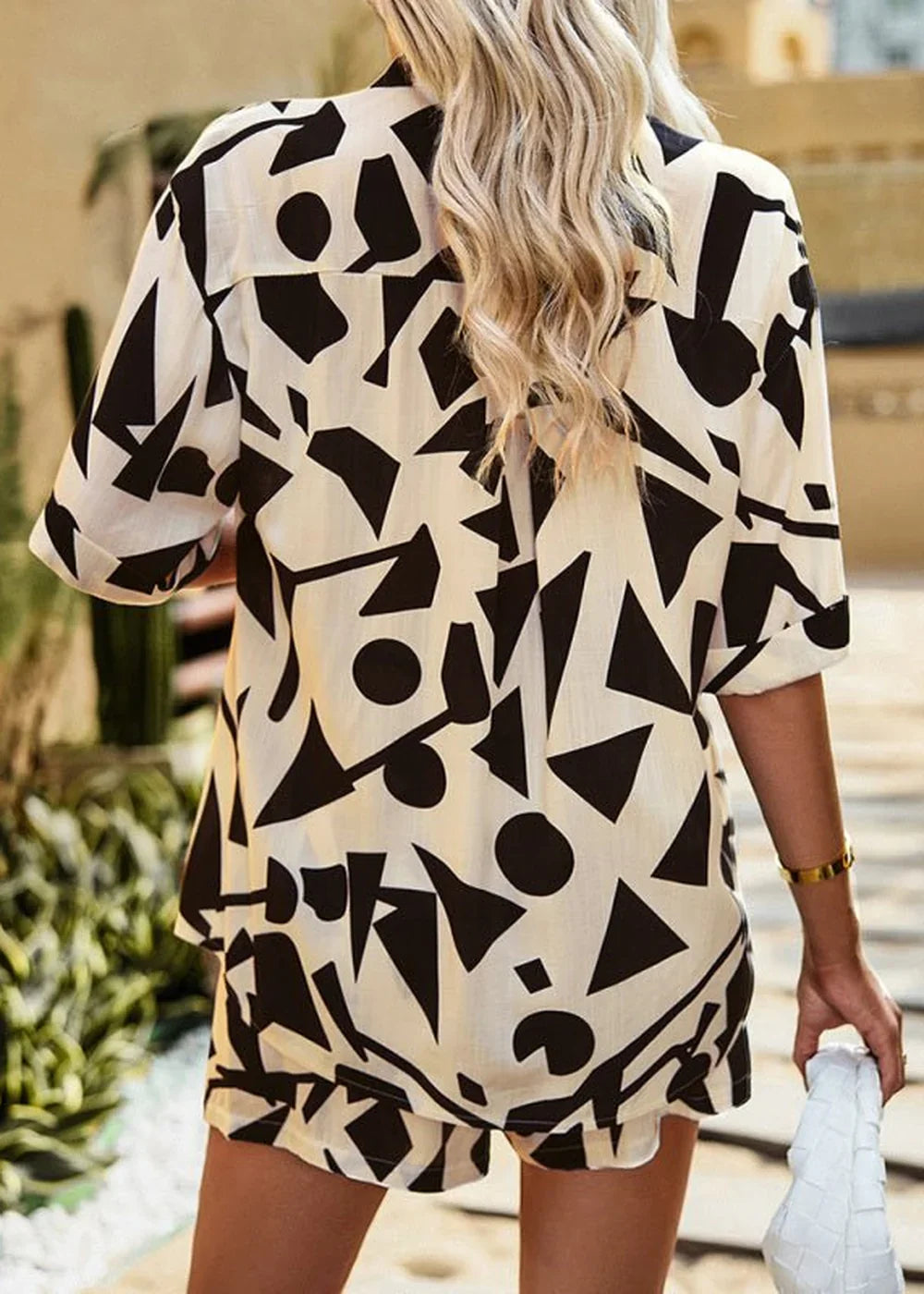 Cream and black abstract geometric print viscose short suit on model.