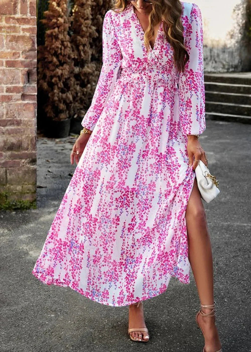 Flowy white maxi dress with a pink floral pattern, V-neck, and long sleeves.