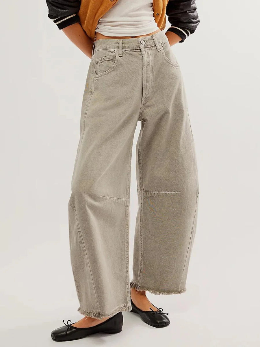 High-waisted wide-leg pants in a light taupe color with a frayed hem and visible stitching details.