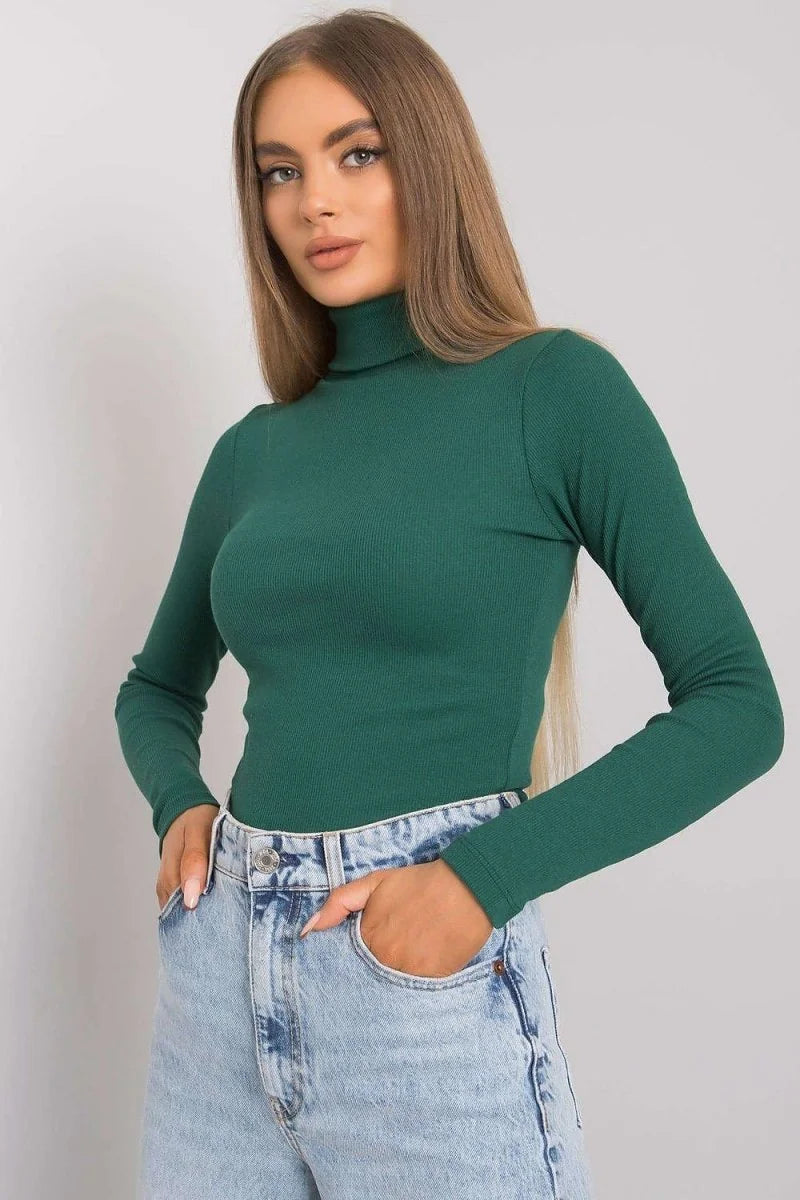 Fitted green ribbed turtleneck top with long sleeves, worn with light wash denim shorts.
