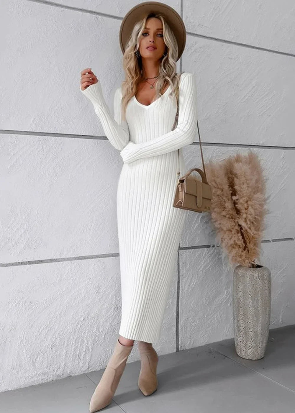 White ribbed knit sweater dress with v-neck and long sleeves, worn by a model with a tan hat and tan boots.