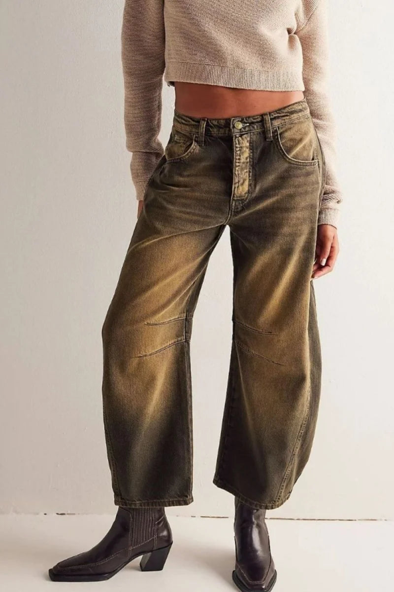 Relaxed fit brown wide-leg jeans with a faded wash and stitching details, worn with brown boots.