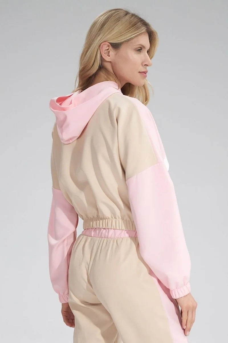 Beige and light pink color-blocked hooded jacket with elastic waistband, worn by a woman.