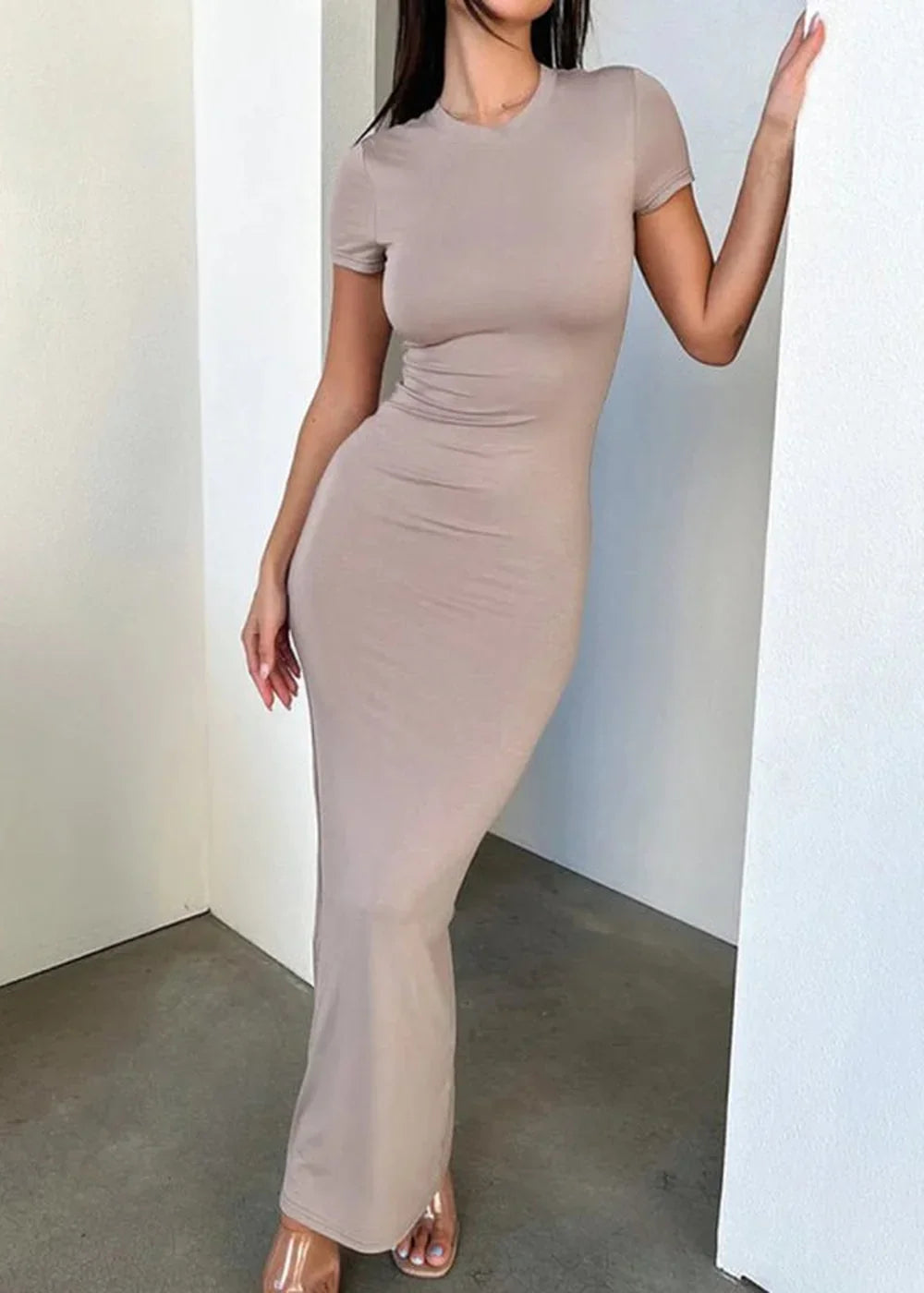 A mocha-colored, form-fitting maxi dress with short sleeves and a crew neck, showing its smooth texture and floor-length hem.