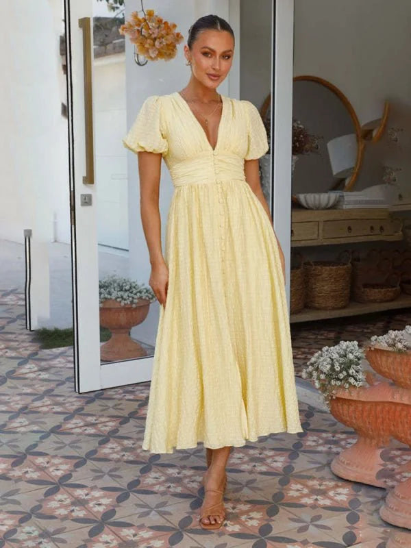 Yellow textured midi dress with a V-neck, button front, and puff sleeves, shown on a model.