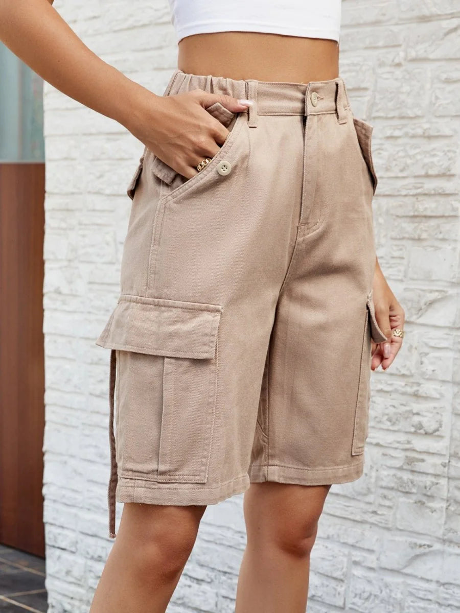 Tan cargo shorts with a drawstring belt and multiple pockets, shown on a model.