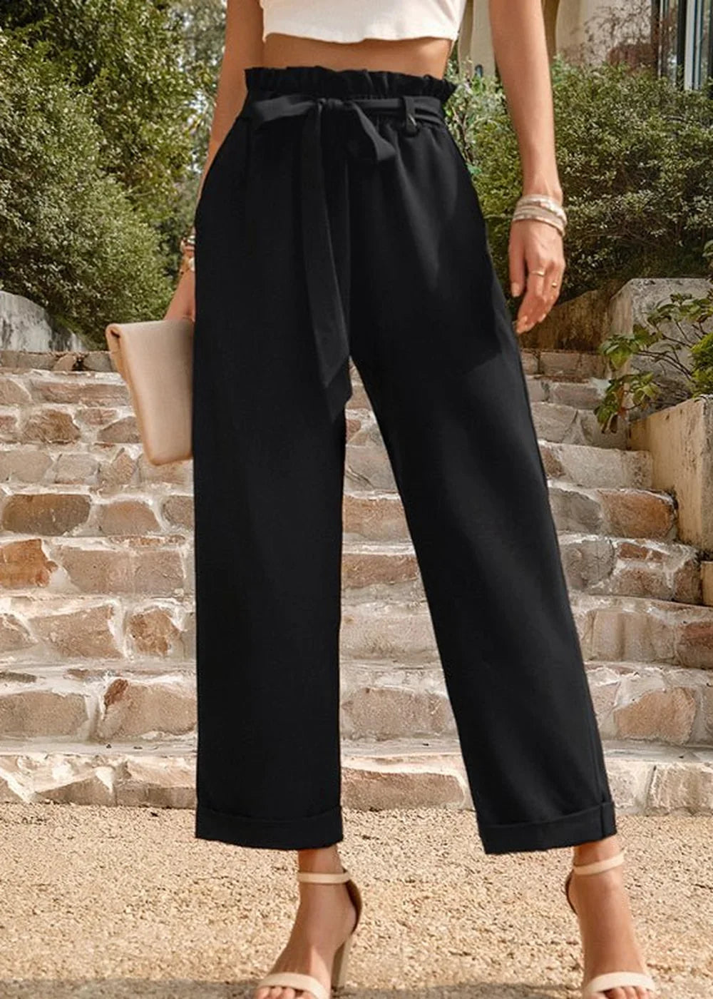 Black high-waisted wide-leg pants with tie belt and rolled cuffs, shown on a model.
