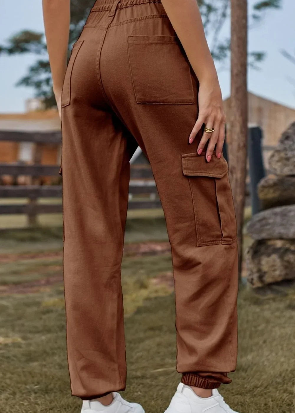 Brown cargo pants with elastic cuffs and pockets, on a model.