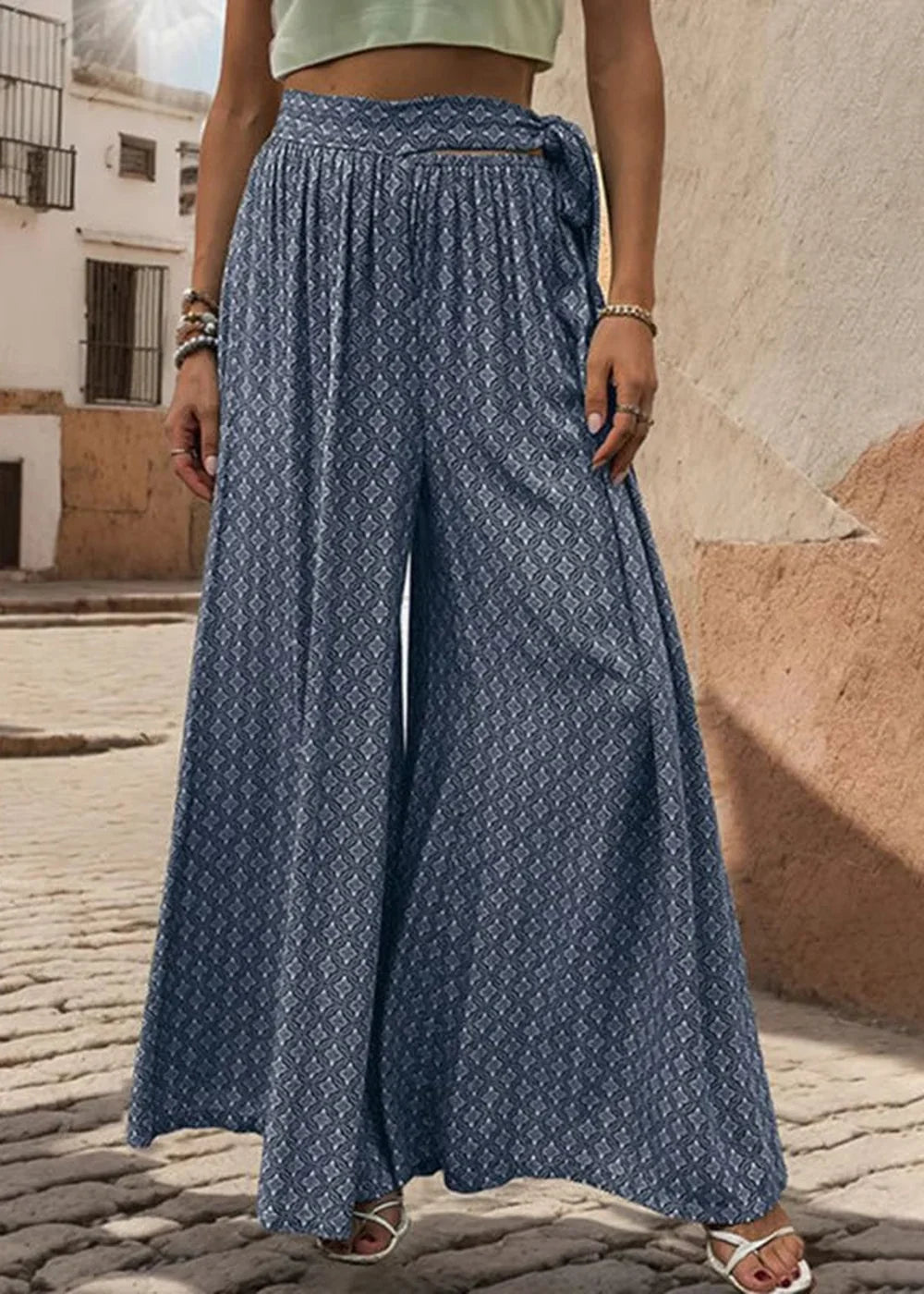 Wide-leg navy blue pants with a geometric print and tie waist, on a model.