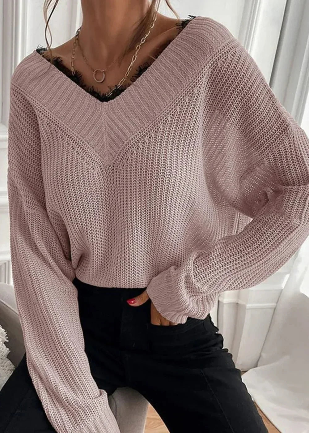 Pink v-neck sweater with black lace trim and a textured knit, worn by a model.