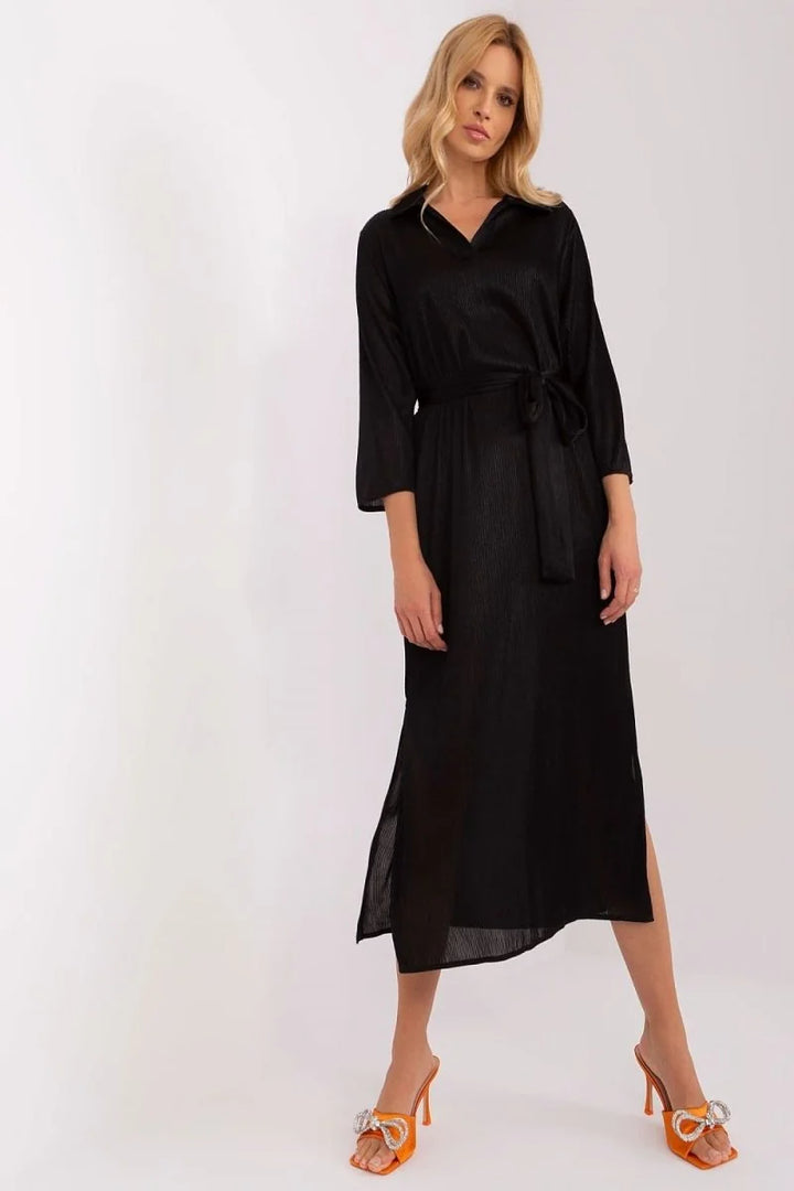 Black pleated midi dress with a belted waist and orange bow heels.