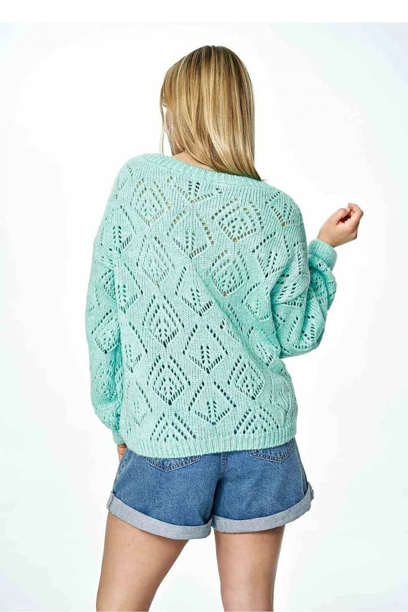 Light green open-knit sweater with diamond pattern, worn by a model with denim shorts.