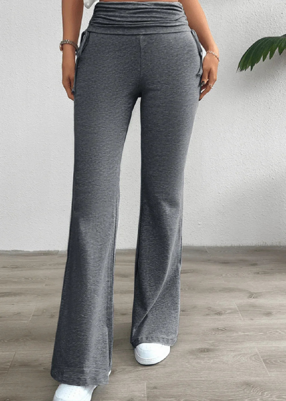 Grey flared pants with a ruched high waist and drawstring detail, on a model.
