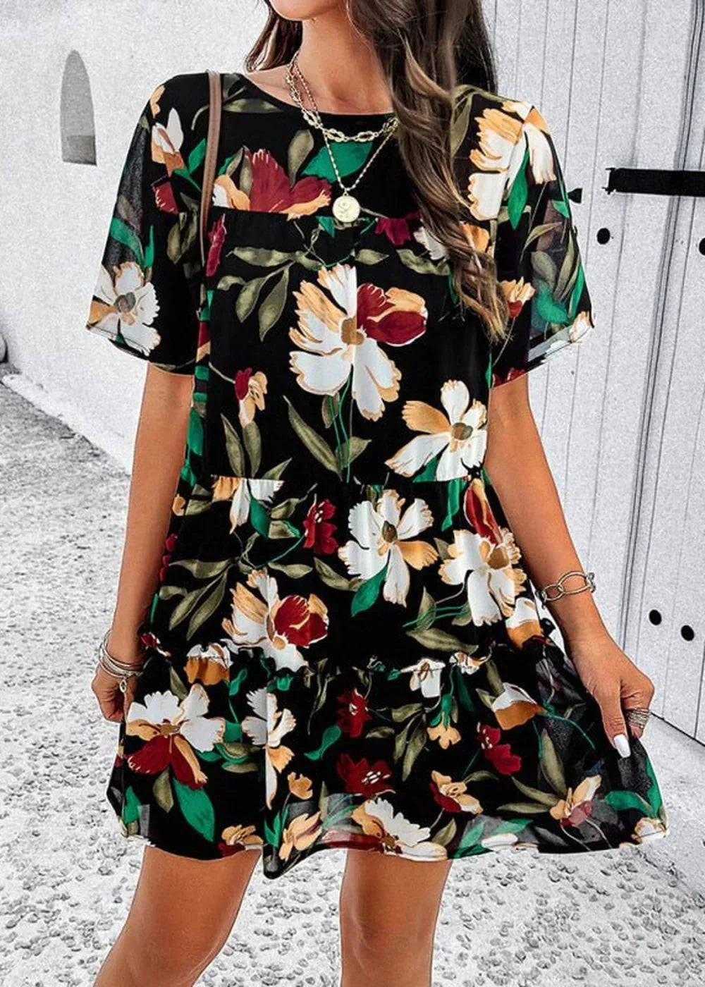 Black floral print mini dress with tiered ruffles and short sleeves, worn by a model.