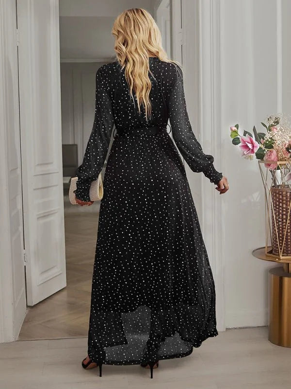 Black polka dot maxi dress with long sleeves and flowing skirt, shown from the back.