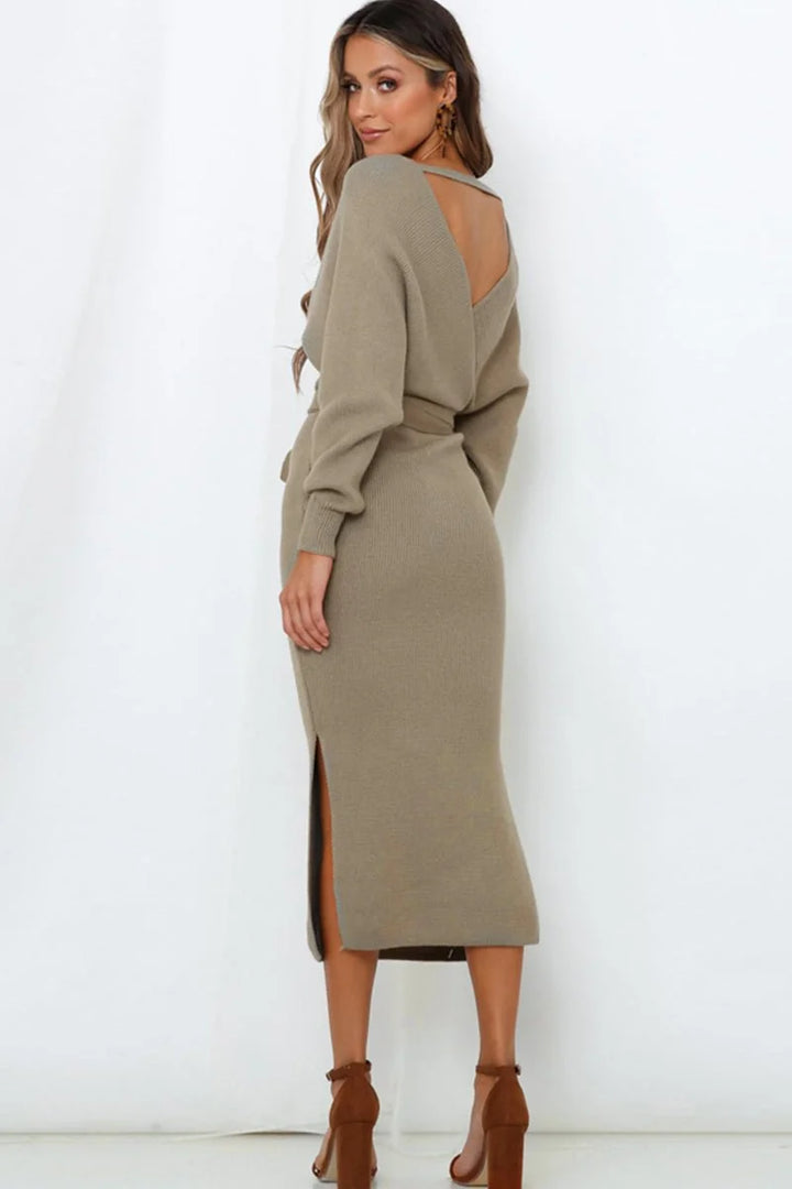 Taupe knit sweater dress with a deep V-neck, belted waist, and a high slit, shown from the back.