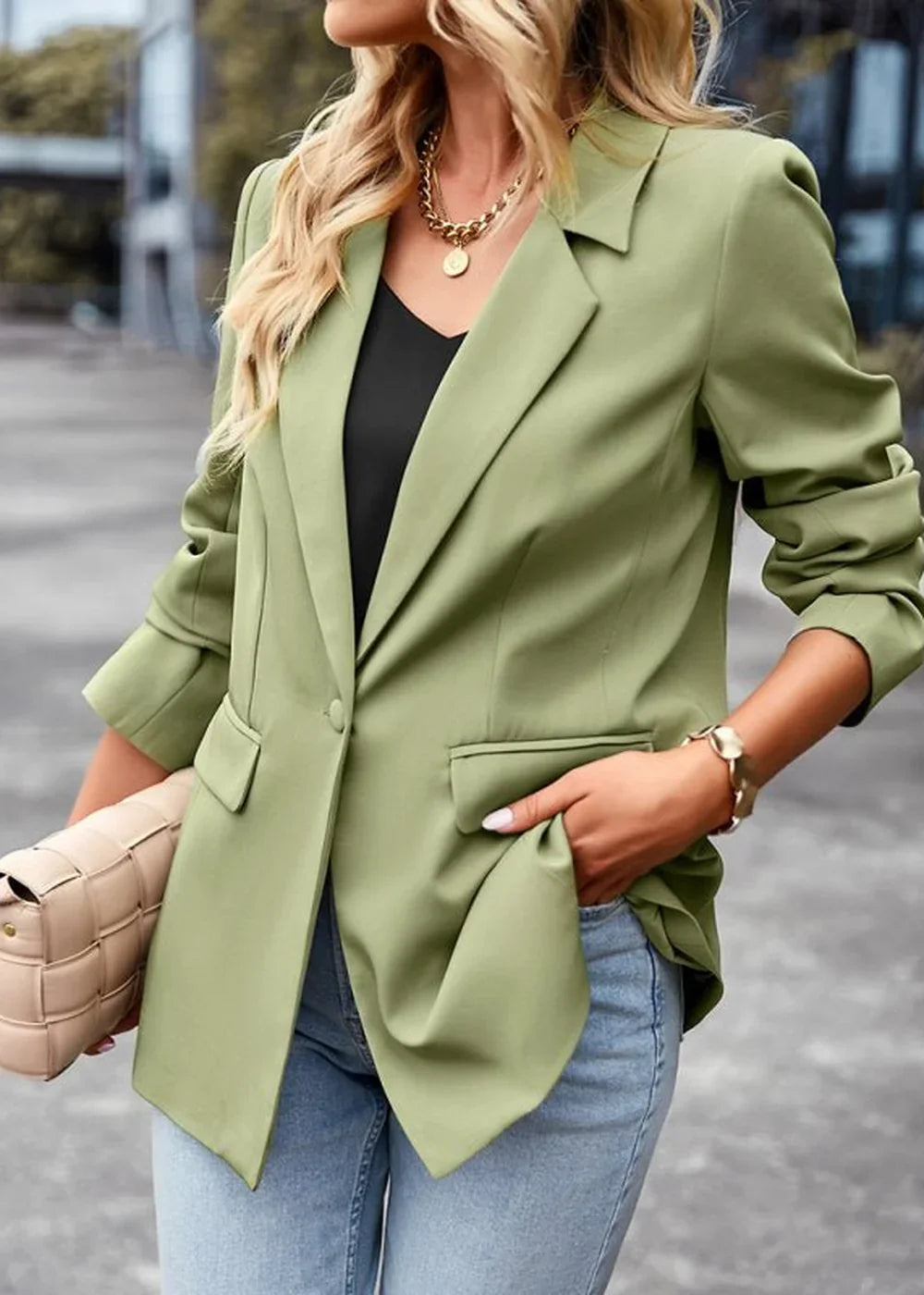 Olive green blazer with single button closure, cuffed sleeves, and gold necklace on model.