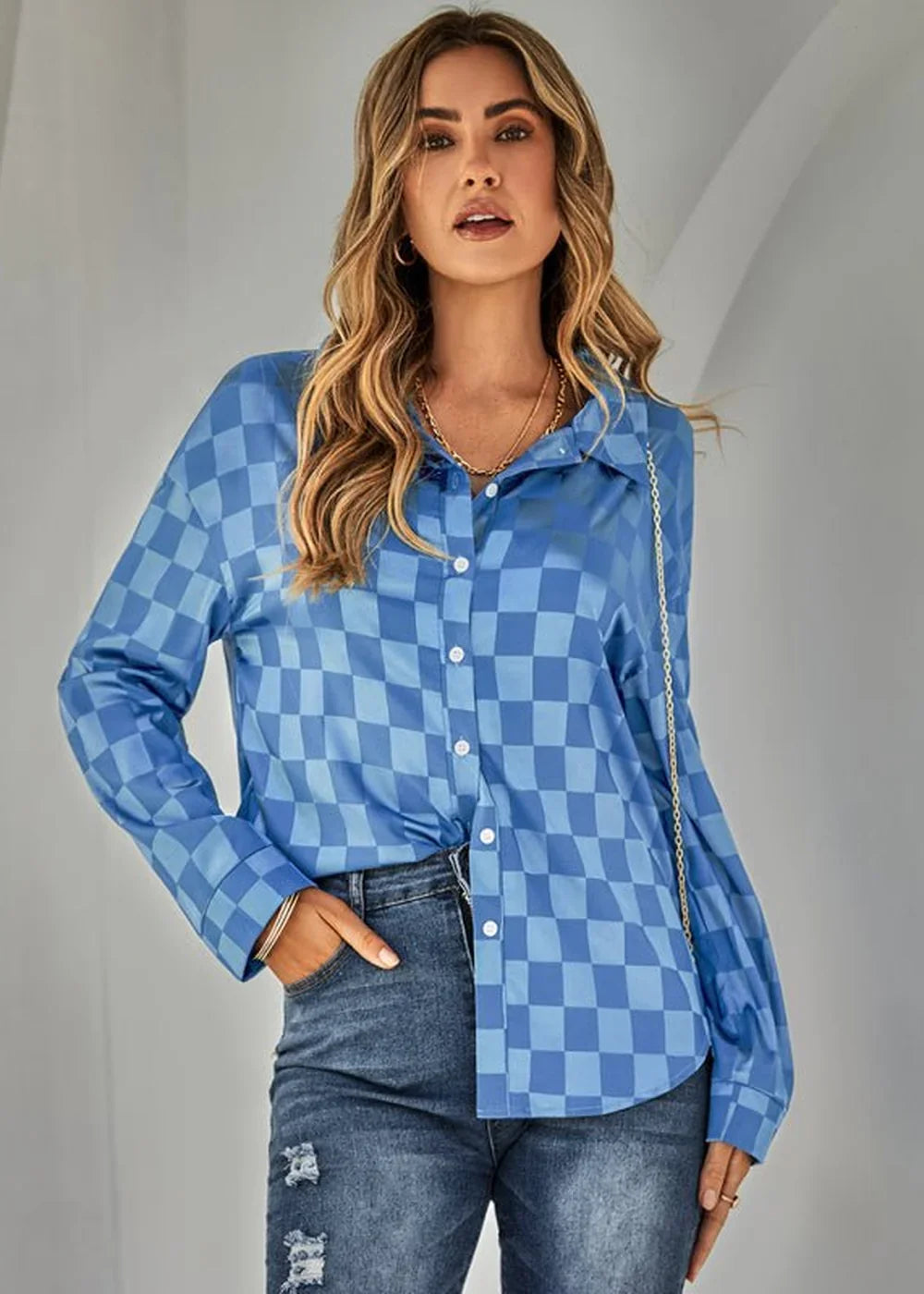Blue and light blue checkered long-sleeve button-up shirt on a model, paired with distressed denim jeans.